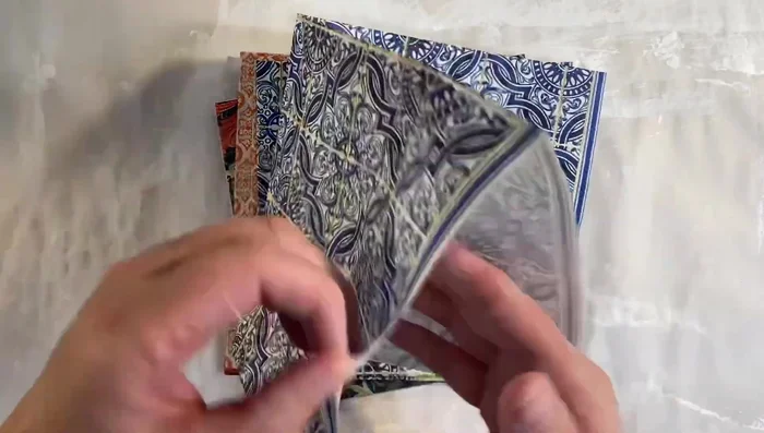 Prepare the napkins: Separate the plies of your chosen napkins, leaving only the top layer. Select napkins with a solid pattern that will completely cover the envelope.