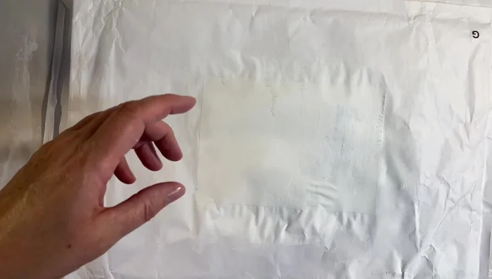 Apply glue and attach the napkin: Generously apply the watered-down PVA glue to the front of the prepared envelope. Carefully place the napkin onto the glued surface, smoothing it out to avoid tearing. Gently press to adhere.