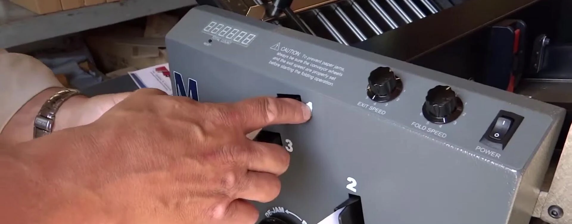 Close-up of the rollers and paper feed path demonstrating the thickness adjustment.