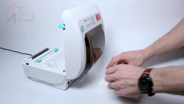 Pull the label through the slot from the front.