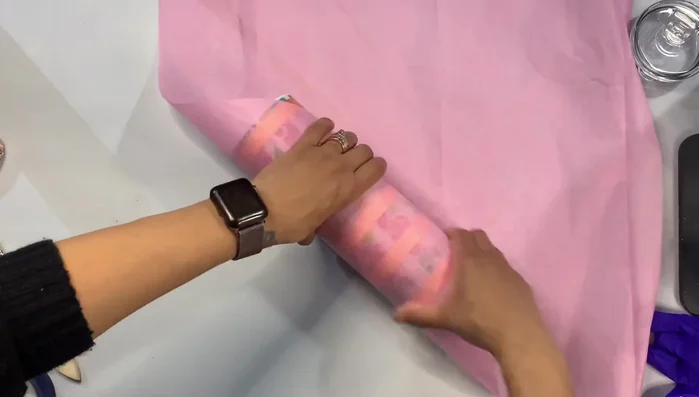 Wrap the tumbler in tissue paper, creating a clean cylinder shape. Secure with a sticker.