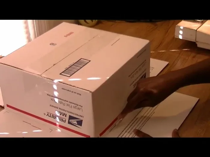 Remove flaps from a cardboard mailer.