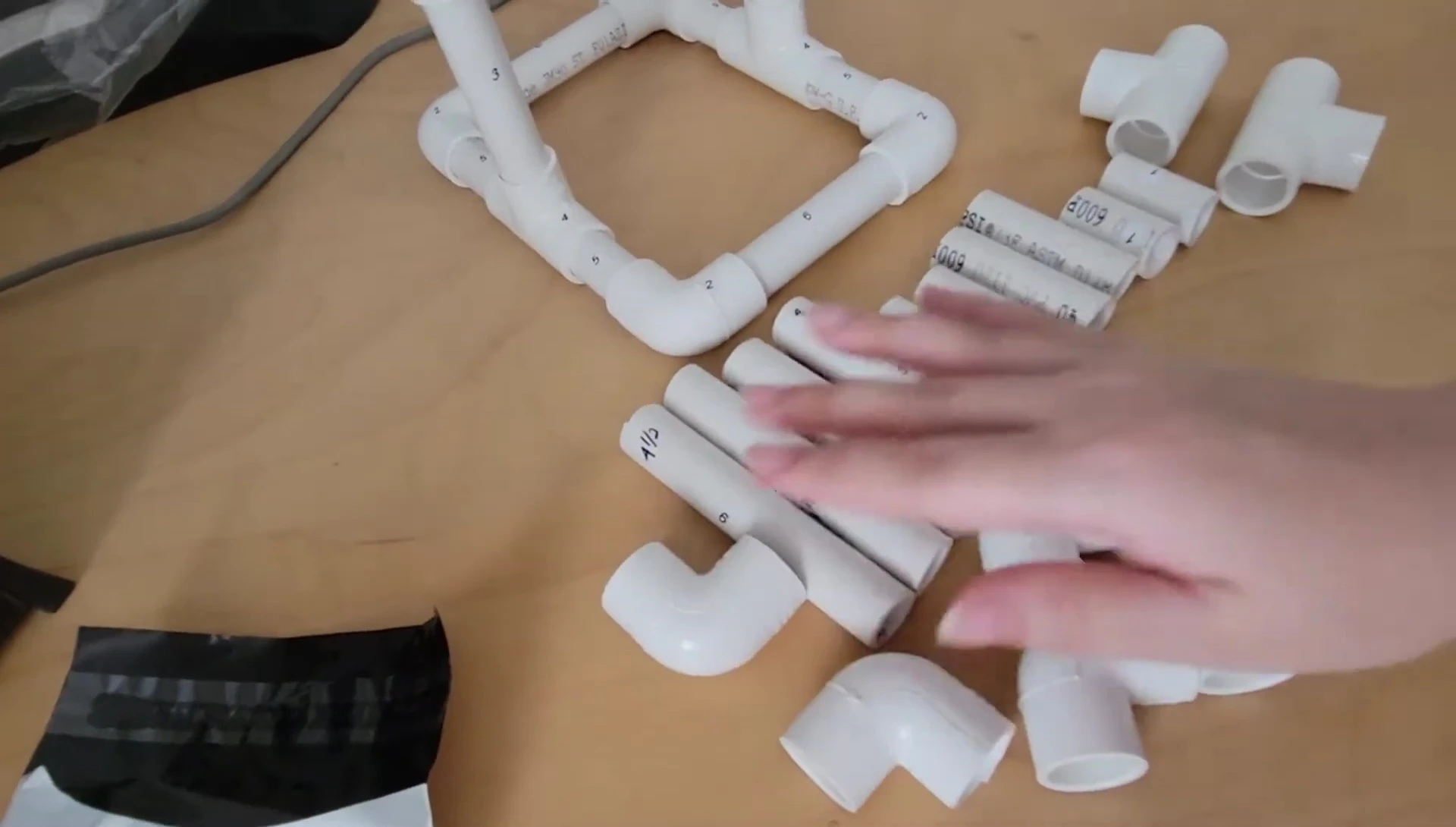 Close-up of the PVC pipes and fittings laid out on a table