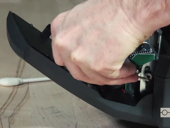 Swing the blade back up and snap the tabs into place. Clean any debris in the cutter's exit chute.