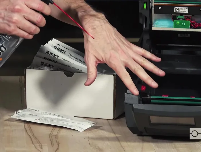 Use short bursts of canned air to clean the print roller area, sensor area below the print roller, and the area above and behind the printhead assembly.