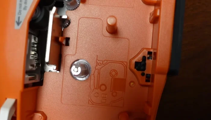 Ensure the open area faces left. Position the tape (TZe221, 3/8 inch recommended) with the bottom edge first.