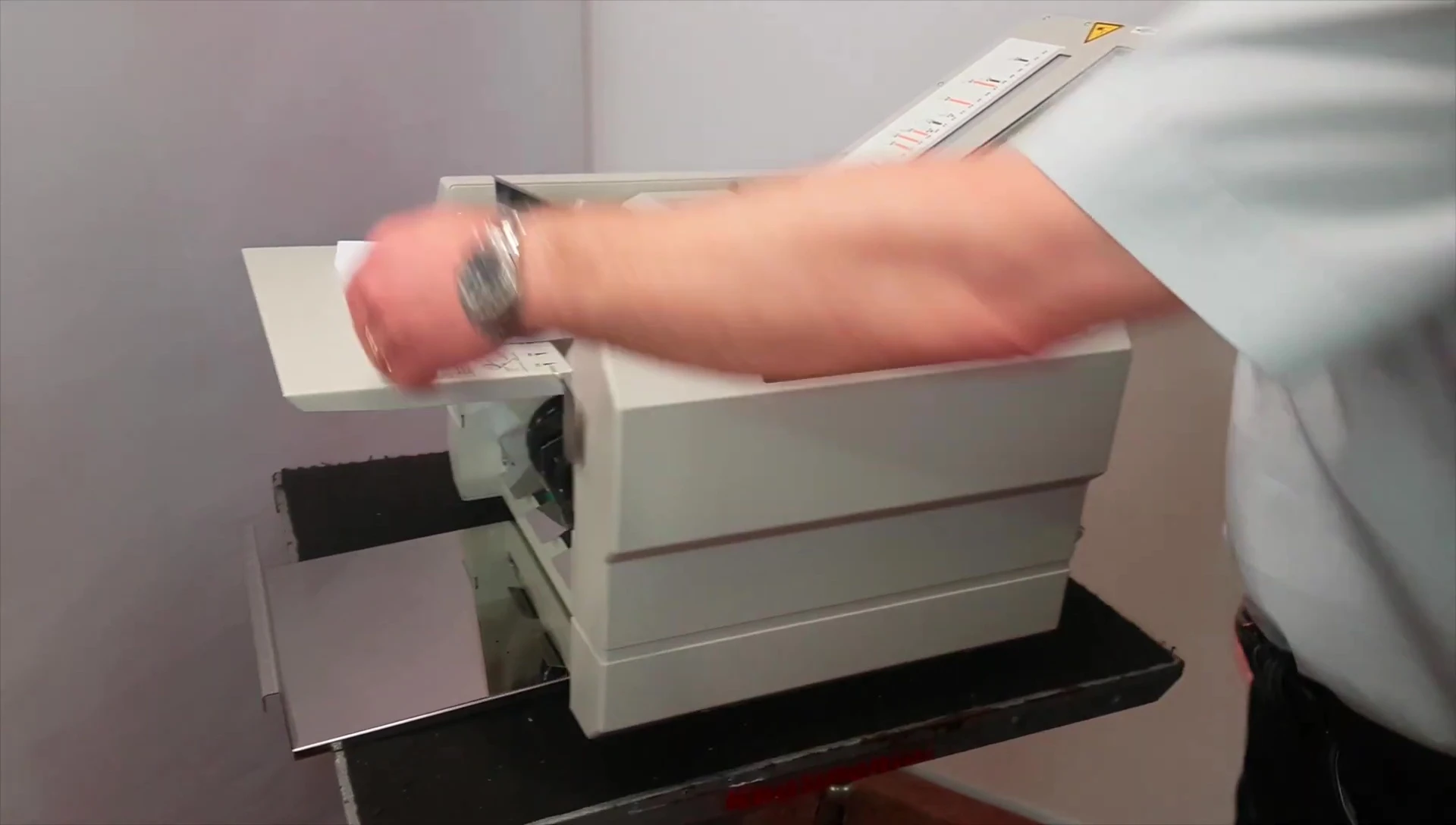 Demonstrating how to load paper into the machine.