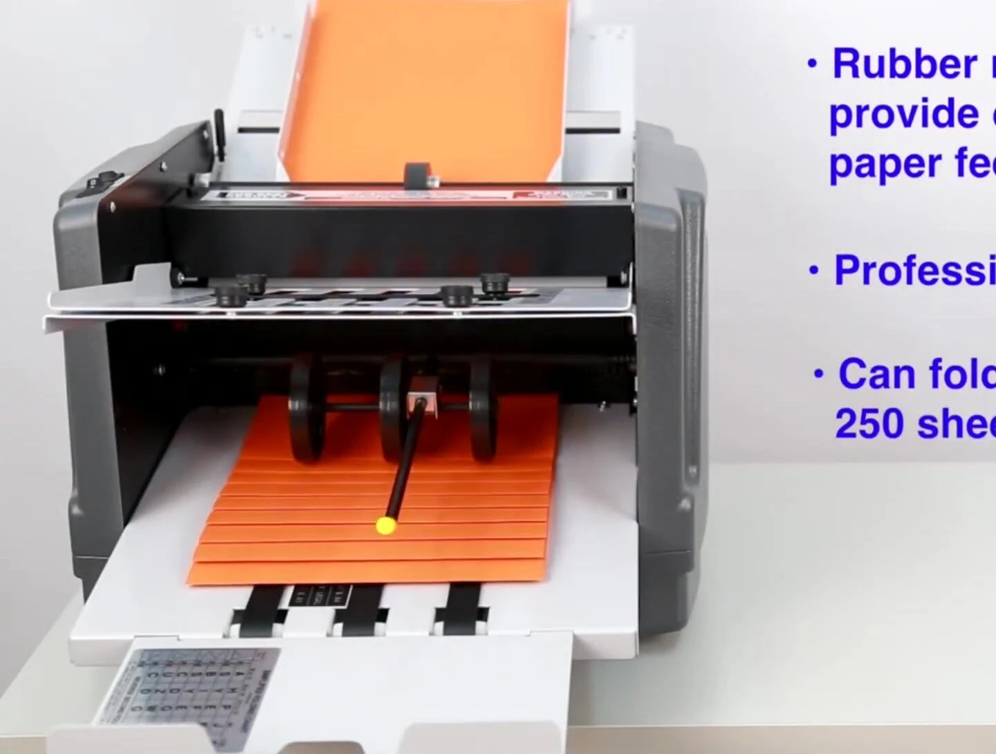 Folded papers exiting the machine and being collected in the exit tray.