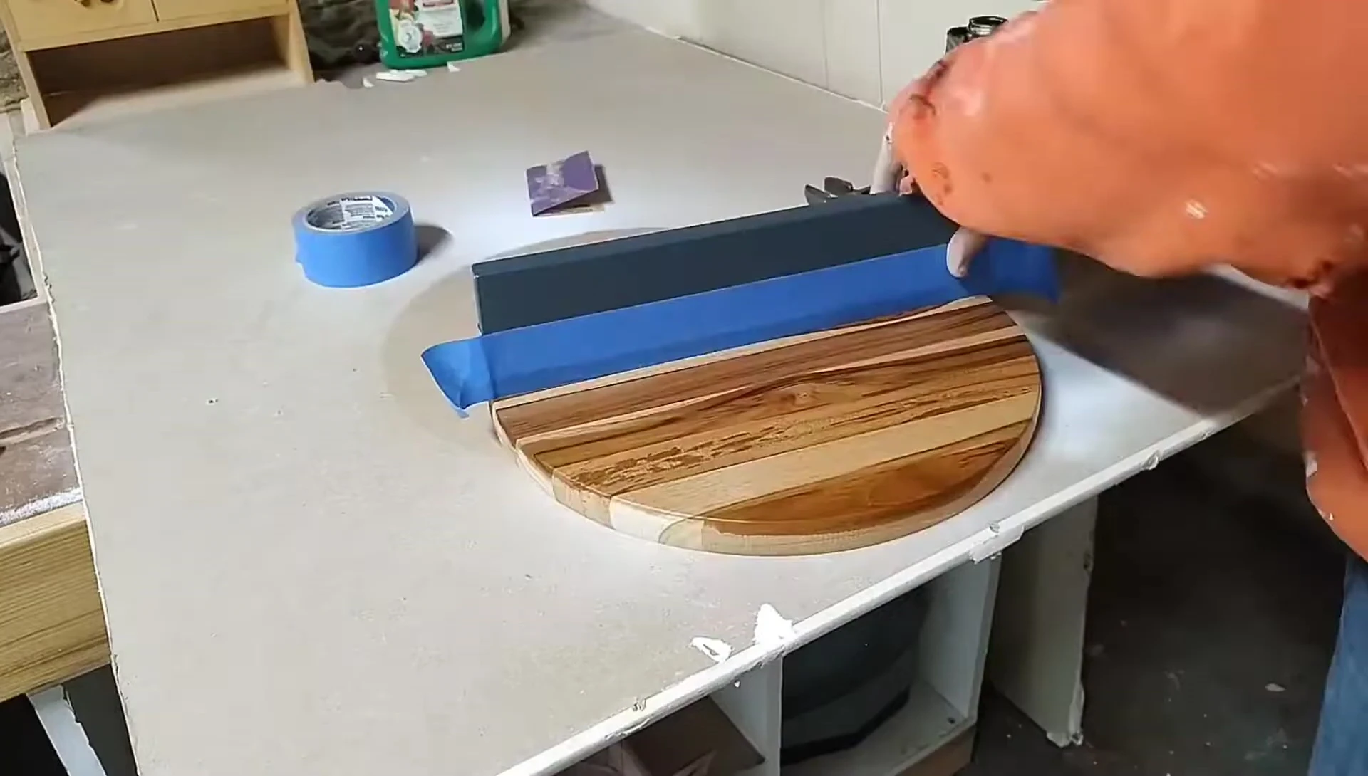 Applying teak oil to the wood round.