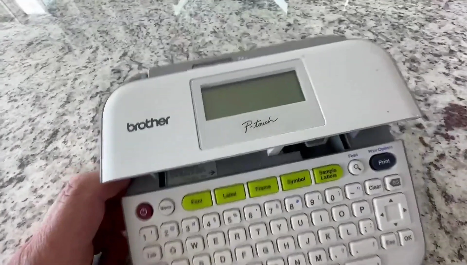 Close-up shot of the Brother P-Touch PTD210 label maker, showing the cartridge slot.
