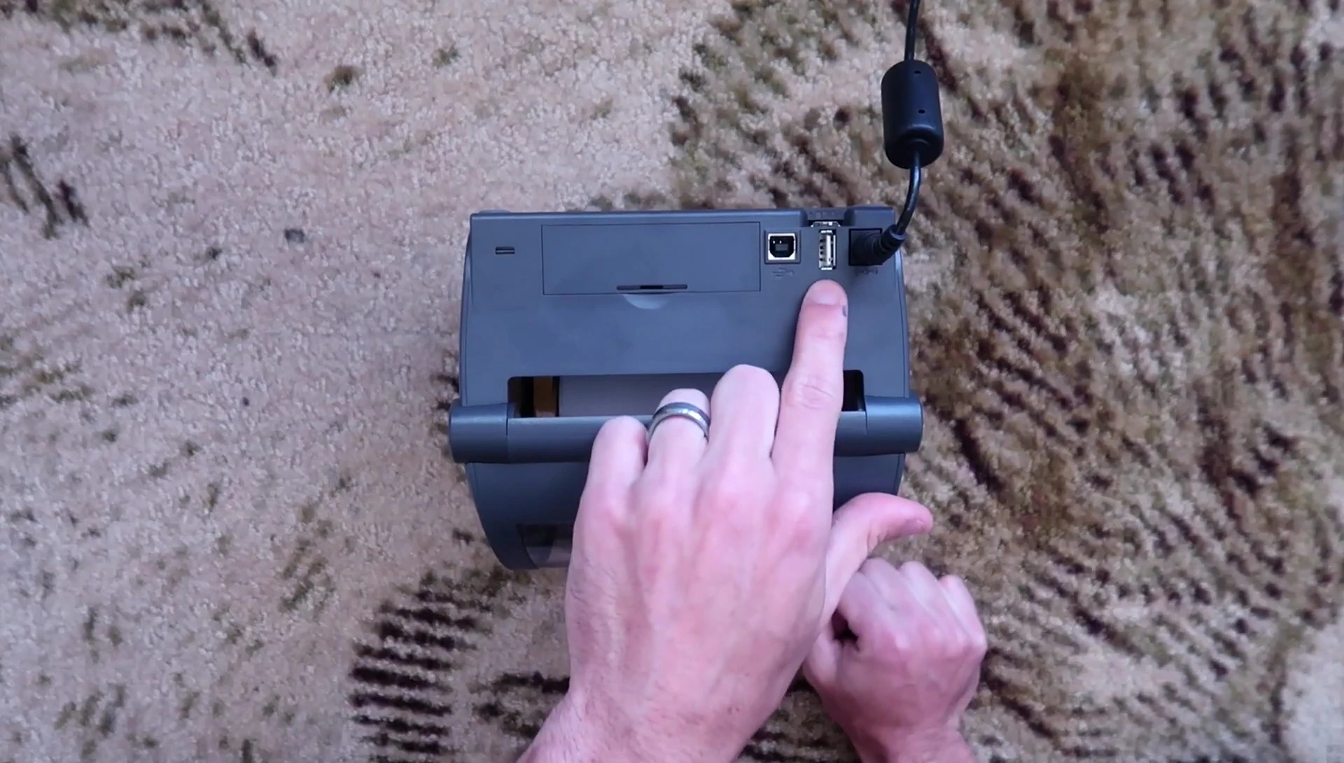 Rear view of the printer showing the power supply, USB port, and auxiliary port.