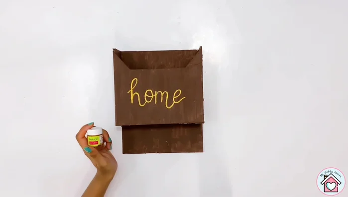 Paint the word "Home" (or any desired word) using golden acrylic paint.
