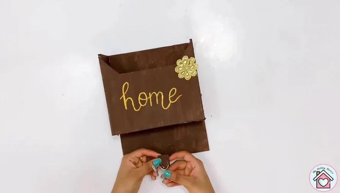 Attach the wall hooks to the bottom of the mailbox using a hot glue gun for key holders.