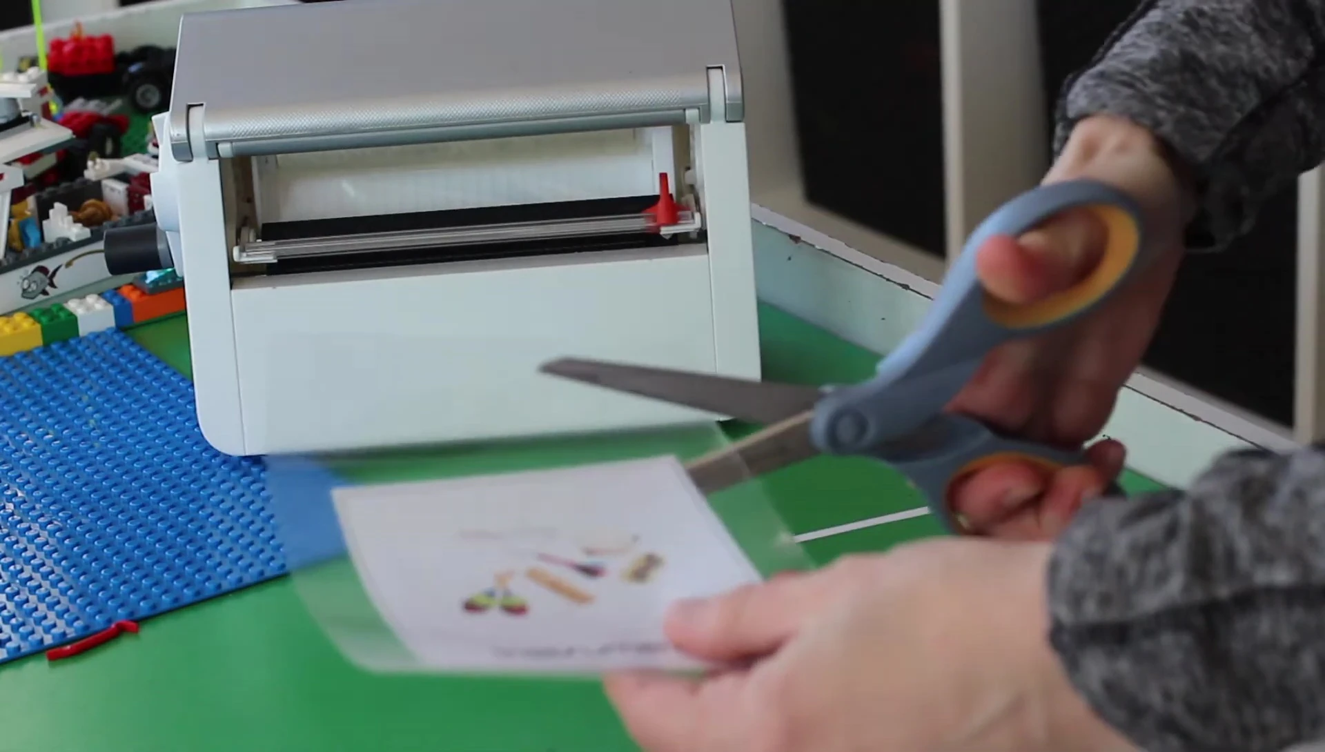 Trimming the excess laminate from a labeled item.