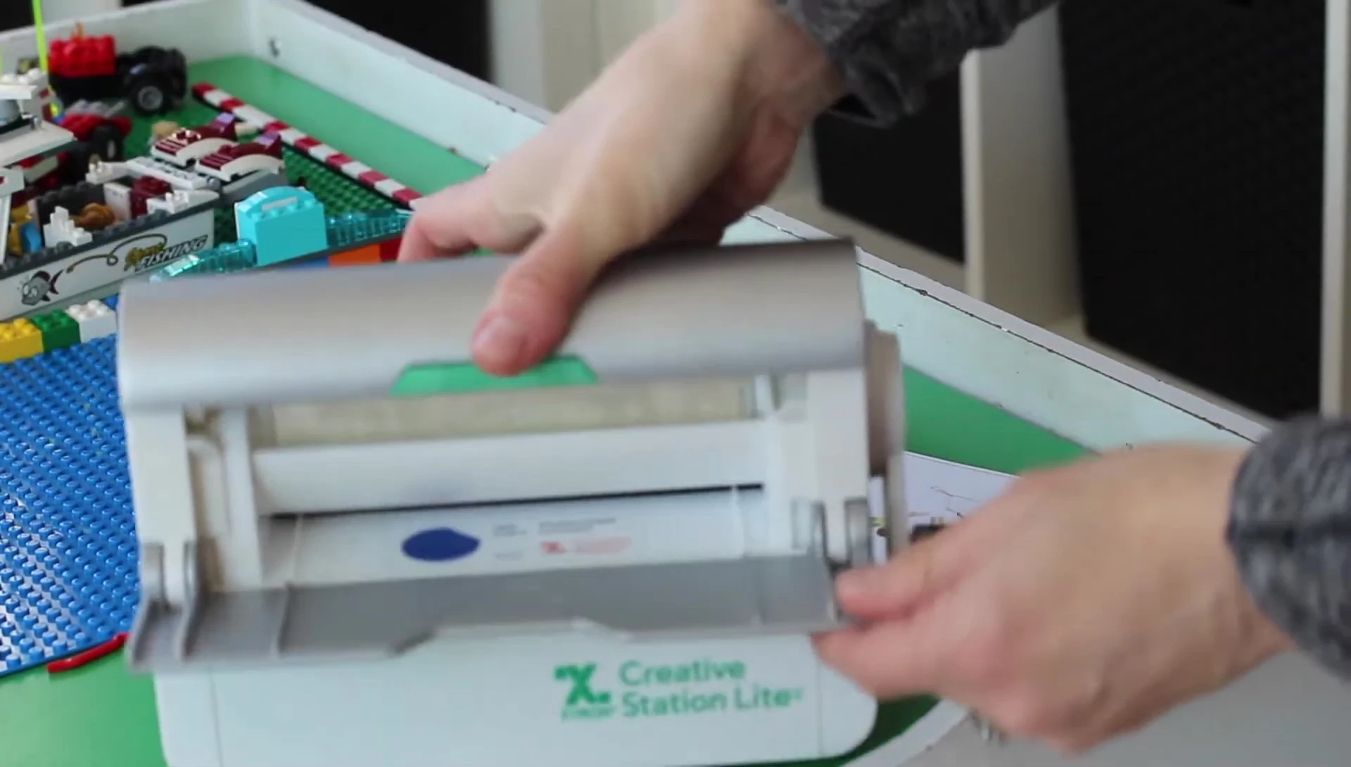 Demonstrating how to run a label through the Xyron Creative Station.