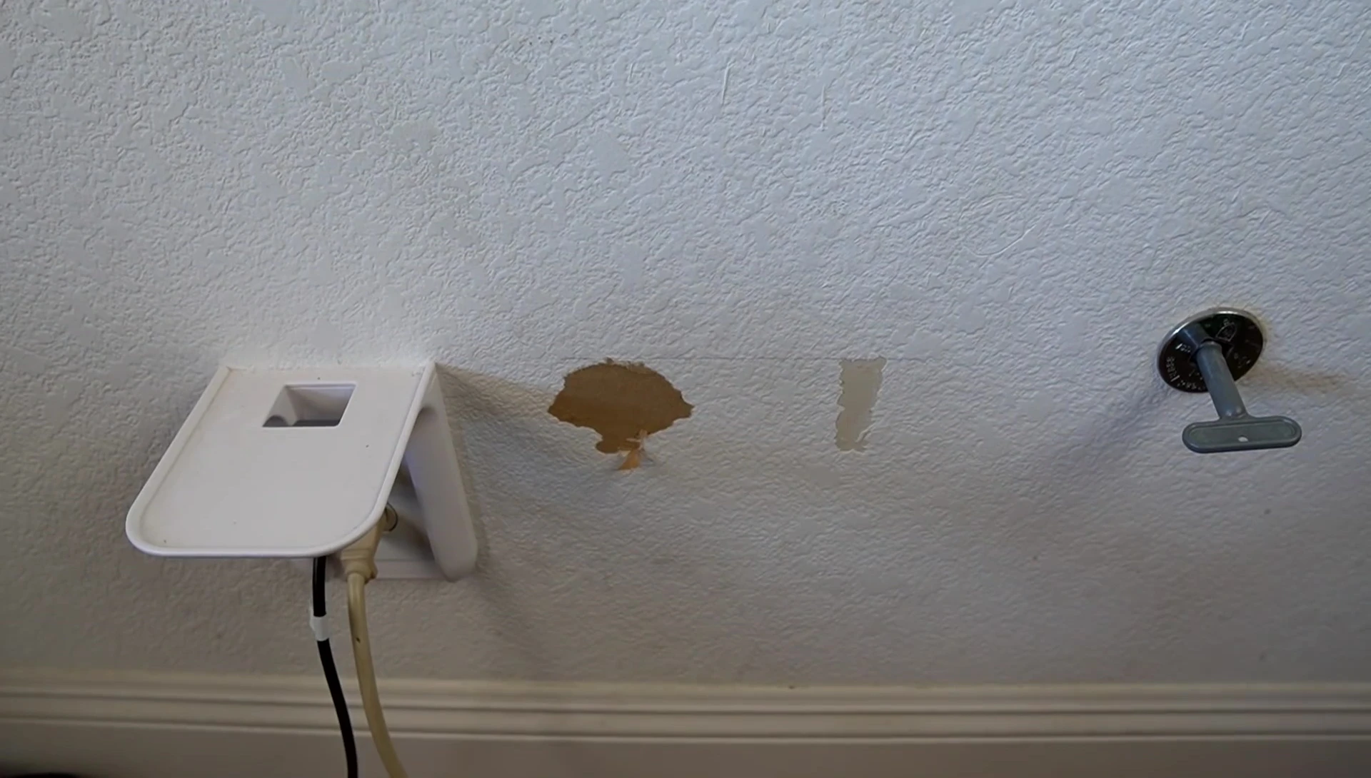 The reviewer demonstrating the damage caused by removing the Wonder Shelf from the wall.