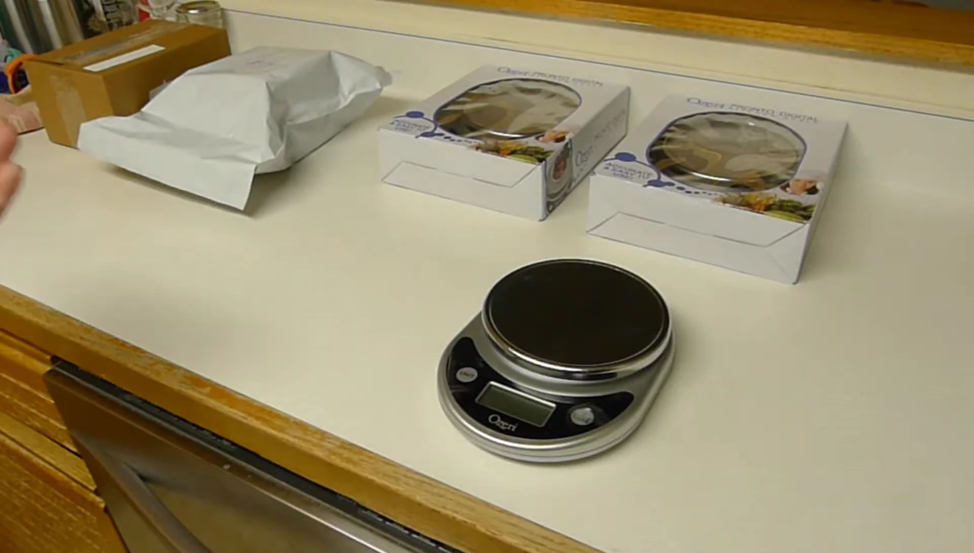 The speaker demonstrates weighing a package on the scale.