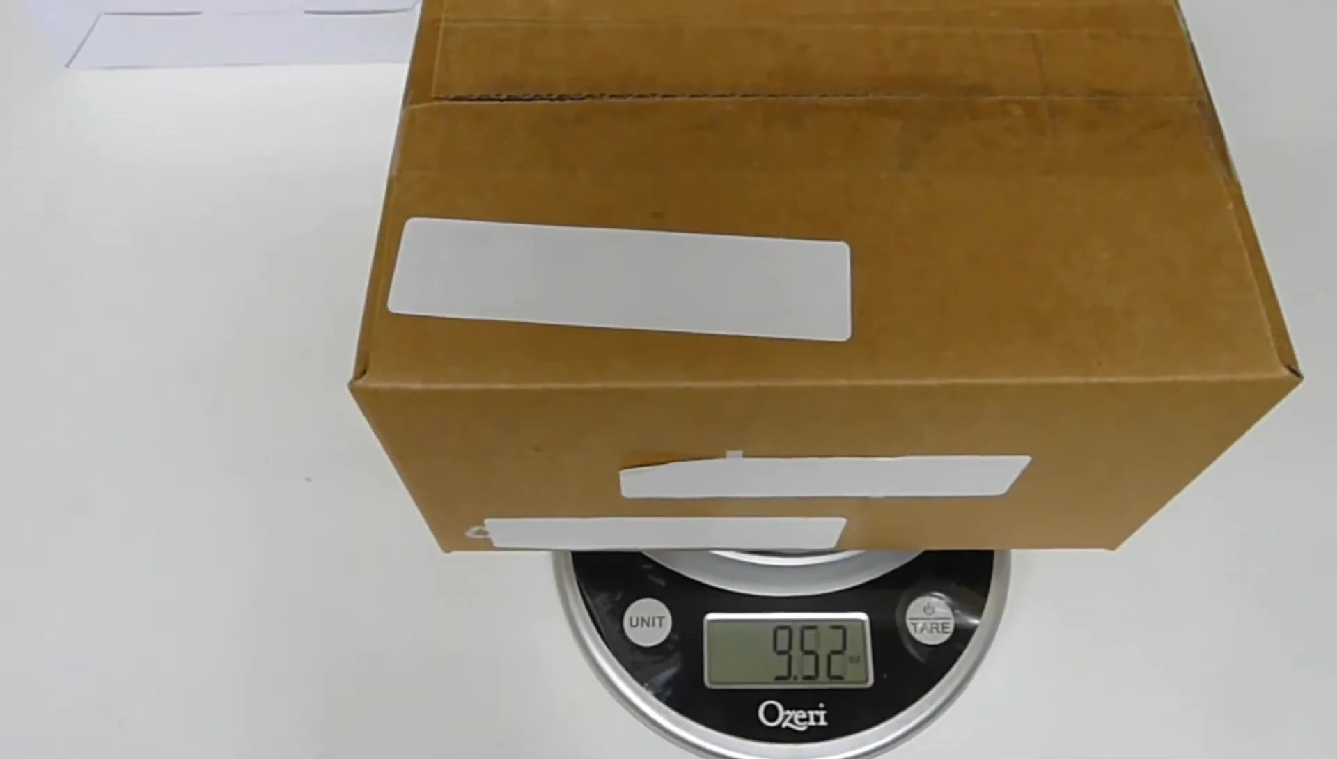 The scale displays the weight of a package (9.21 ounces).